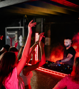 People dancing at a nightclub with a DJ