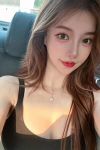 Attractive young woman with long brown hair, wearing a black top and necklace.